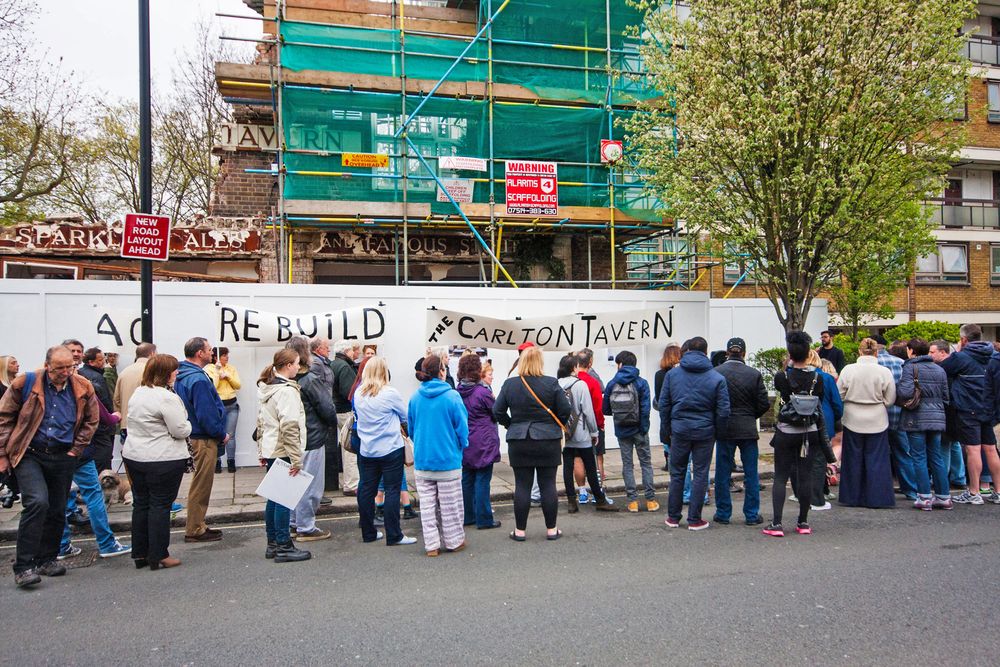 Dozens of local residents and regulars gather outside the much loved, partially demolished Carlton Tavern in Maida Vale to protest against its sudden, illegal demolition by property developers, April 26th 2015