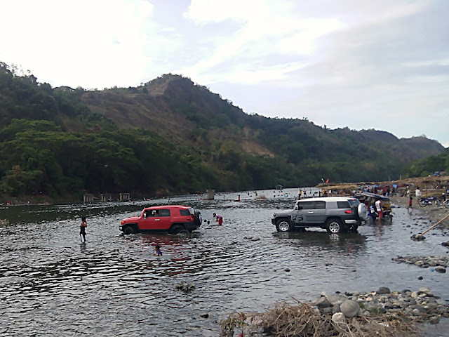 people and vehicles at the Pinacanauan River