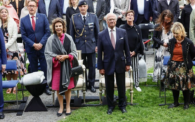 Queen Silvia wore a fuchsia pink tweed jacket and skirt by Chanel, and black leather bag and black leather pumps