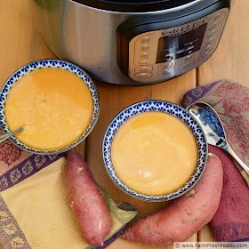 pic of 2 bowls of curried sweet potato soup and an Instant Pot on a table with napkins and sweet potatoes
