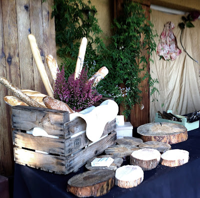 bodegon de quesos hecho con troncos de madera, caja antigua, panes y brezos