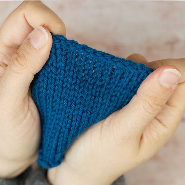hands holding blue knitting with Icelandic Bind Off