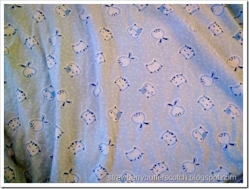 A close up of the cute print of the night gown, it's blue with little bunnies, kitties and cows.