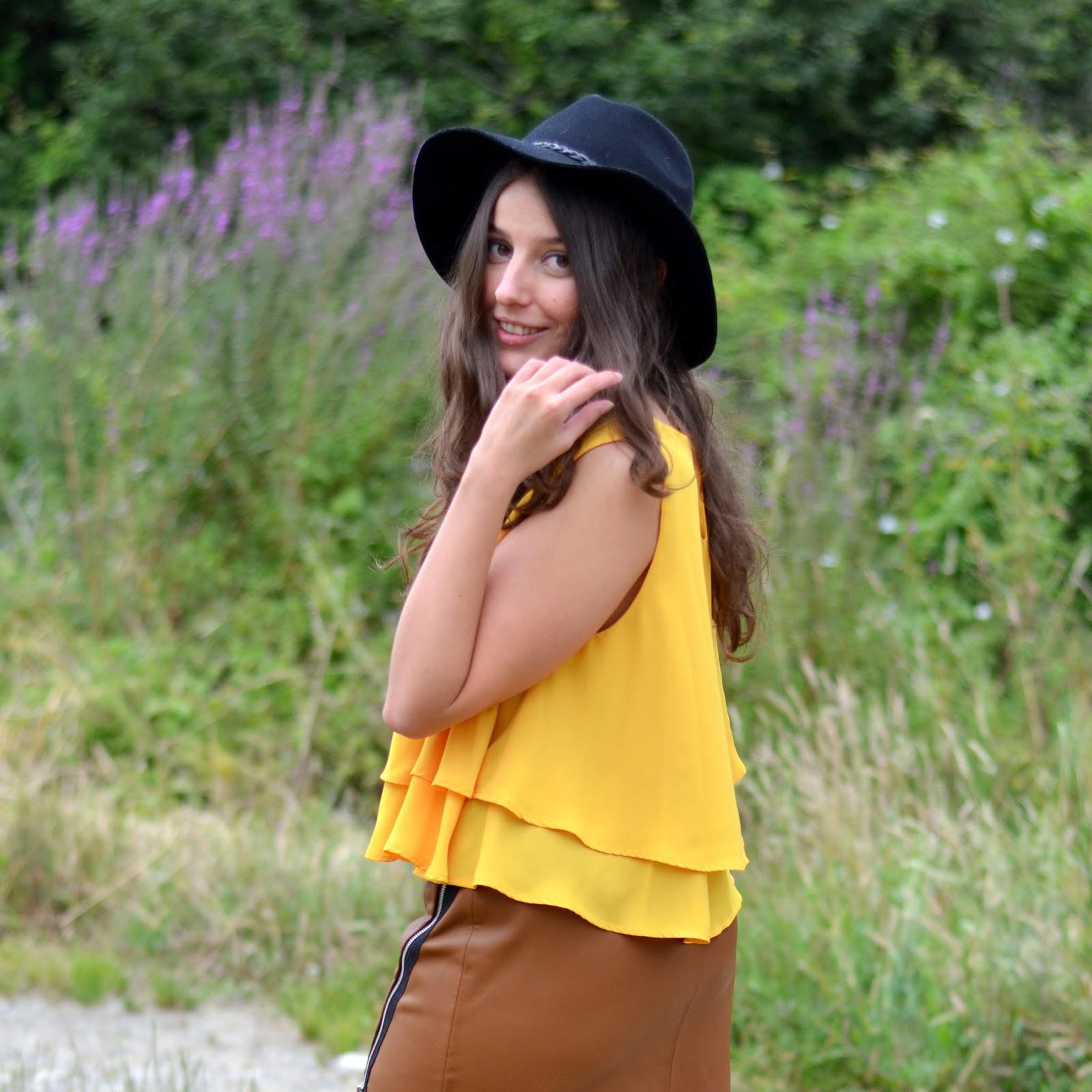 leatherette brown skirt, mustard top, black hat