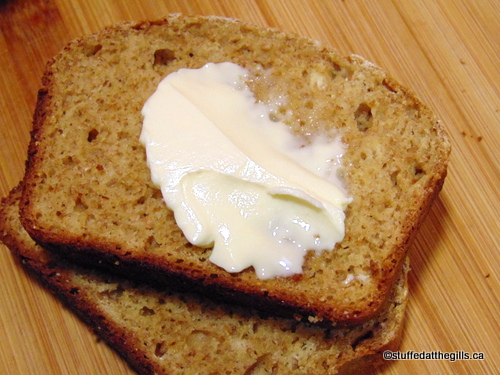 Two slices of Whole Wheat Quick Bread spread with butter.