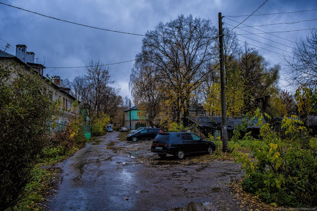 Машины припаркованы в грязи у дома