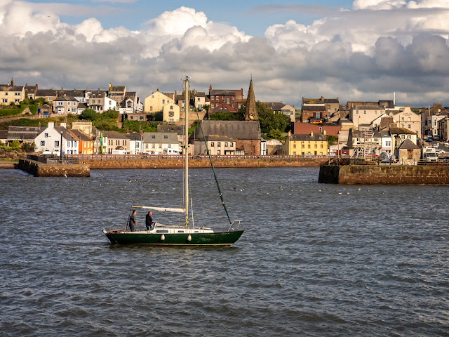 Photo of the same yacht with the town in the background as it heads for the marina