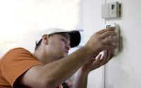 A homeowner installing a programable thermostat a part of an Energy Department program that assists homeowners weatherize their homes. (Image Credit: U.S. National Renewable Energy Lab/Dennis Schroeder, public domain) Click to Enlarge.