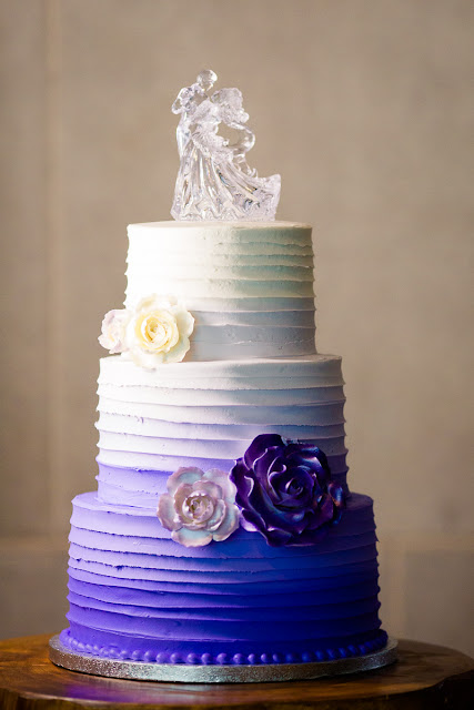 Their wedding cake is in gradient shades of white, lavender and deep purple.  The cake topper is made of crystal and represents the couple dancing.  Taken at the Sam Noble Oklahoma Museum of Natural History in Norman, OK.