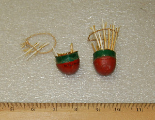 Remnants of badminton shuttlecocks - red rounded end and green band with bits of wood stuck in rim