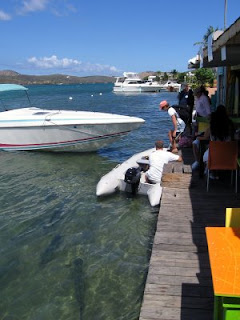 Nan getting into the dinghy with John at the Dinghy Dock while the giant tarpon look on