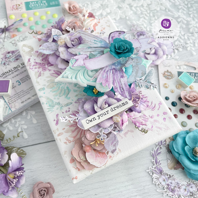 Mixed media canvas featuring a hummingbird and paper flowers from the Prima Marketing The 3 Girls Tale collections Lost in Wonderland, Postcards from Paradise and Aquarelle Dreams.