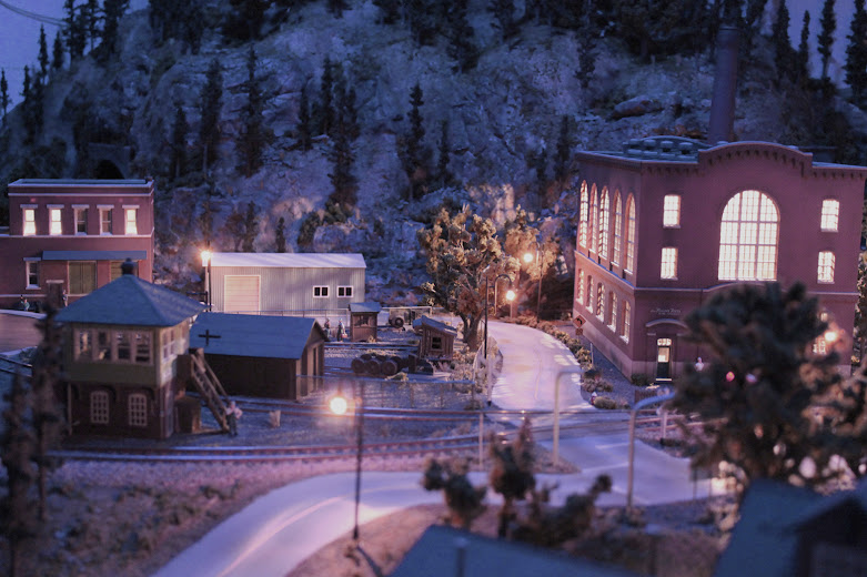 HO scale model railroad layout industrial scene at night with accessory lighting effects