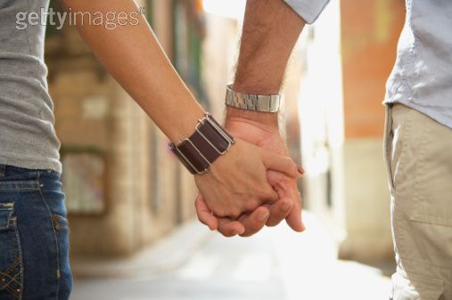 people holding hands walking