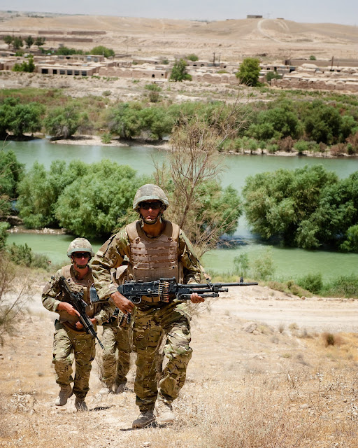 A foot patrol of Royal Marines from Delta Company of 40 Commando passes near Kajaki Afghanistan on the 18th of June 2010