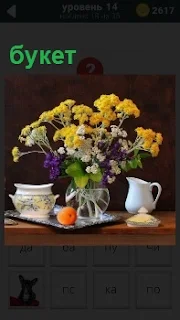 На столе в вазе стоит букет красивых цветов рядом с чашкой и кувшином с водой