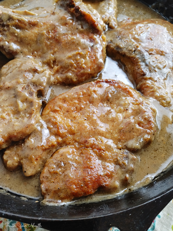 Smothered Pork Chops! A simple one-pan recipe for fork-tender pork chops smothered in gravy that thickens as the chops bake and tenderizes them low and slow in the oven.