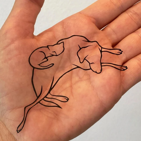 palm size papercutting of sleeping dog and cat huddled together