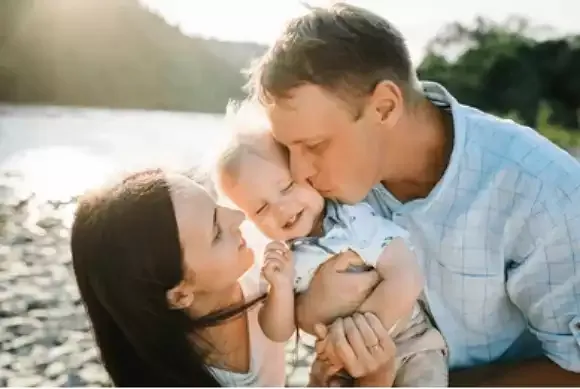 Pais e filho se abraçando ao ar livre.