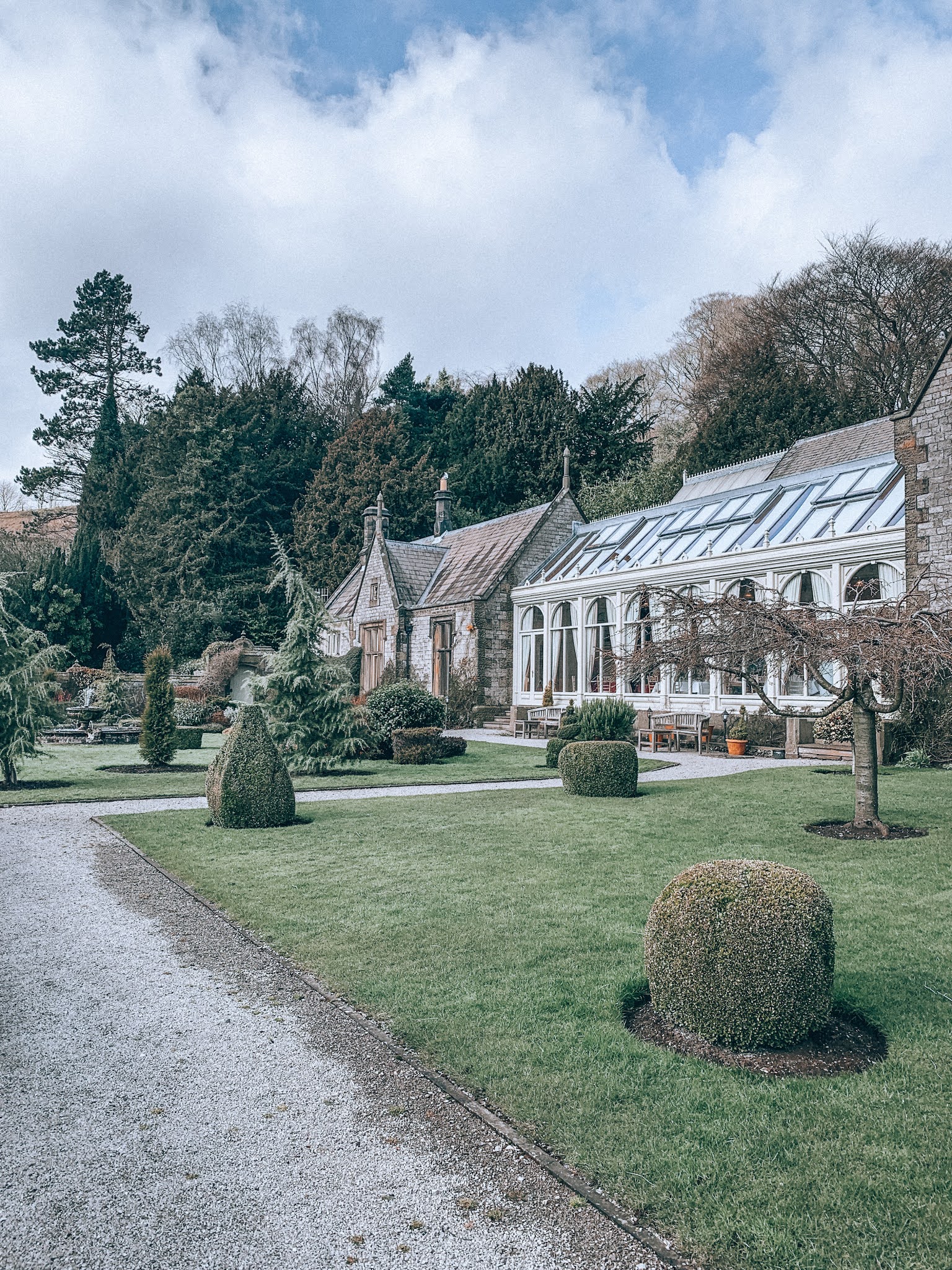 Outside of a stately greenhouse with gardens.