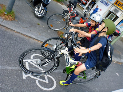 Zwei Schüler mit Fahrradhelmen quatschen auf dem Radstreifen