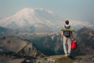 A hiking male with a backpack enjoying a mountain top view