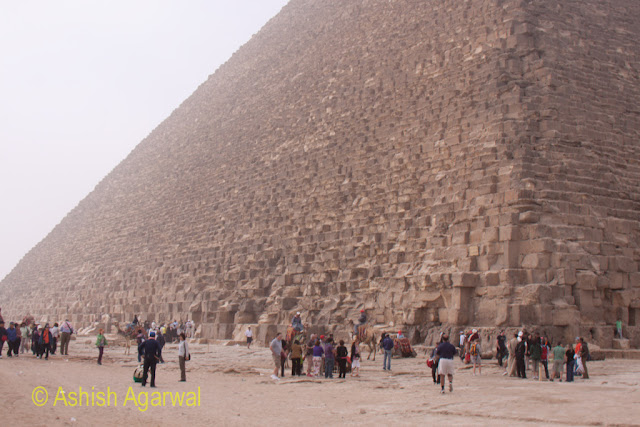 Cairo Pyramids - Side view of the Great Pyramid along with a number of tourist groups at the base