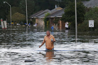 A man wades through a flooded street in Ascension Parish, Louisiana, Aug. 15, 2016. (Credit: Jonathan Bachman / Reuters) Click to Enlarge.