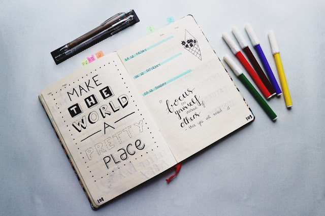 bullet journal with motivational quotes and color markers at the right of the notebook