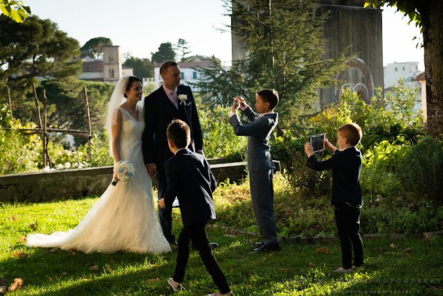 Children taking pictures of the bride and groom