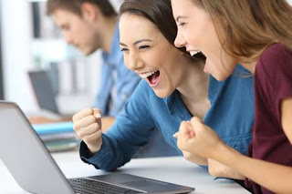 Two business women smiling so much and looking at their laptop.