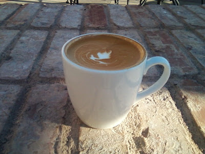 Latte with brown foam on top in a white mug, delicious