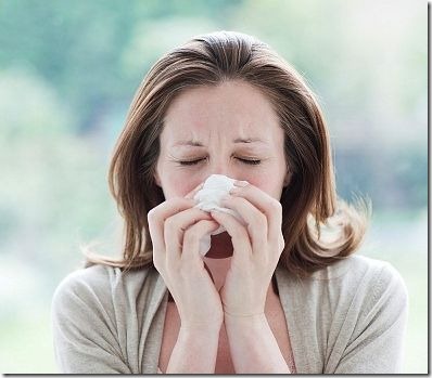 woman rubbing nose with hanky