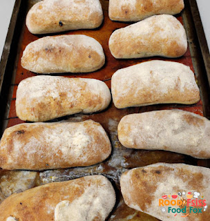  A photo of freshly baked ciabatta bread on a baking tray, golden brown and with a crusty exterior. 