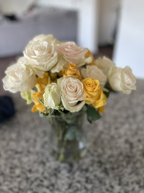 Yellow and white roses sitting on the kitchen island.