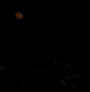 The moon above the town lights