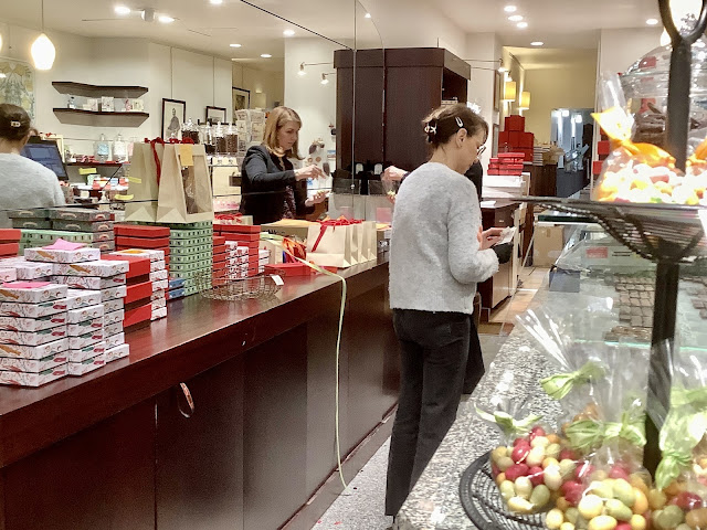 Women wrapping up chocolate boxes in shop