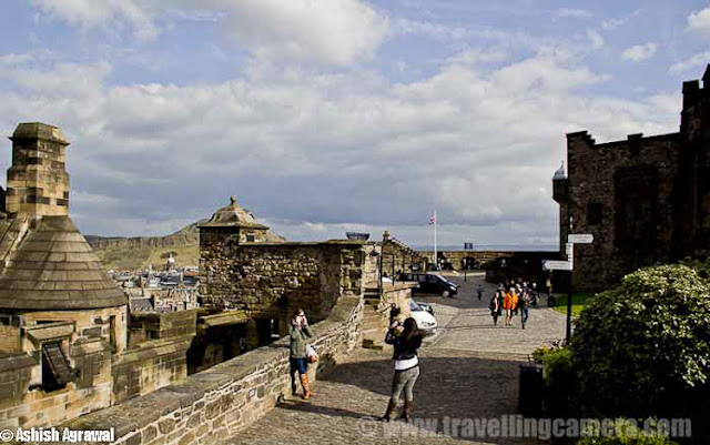 Edinburgh Castle is a fortress which dominates the skyline of the city of Edinburgh, Scotland !!! Human habitation of the site is dated back as far as the 9th century BC, although the nature of early settlement is not clear.  As one of the most important fortresses in the Kingdom of Scotland, Edinburgh Castle was involved in many historical conflicts, from the Wars of Scottish Independence ...Although Edinburgh Castle is formally owned by the Ministry of Defence of Scotland but most of the castle is now in the care of Historic Scotland and it is Scotland's most-visited paid tourist attraction.Edinburgh - Castle and train station !!The garrison left in the 1920s, but there is still a military presence at the castle... Military is largely ceremonial and administrative and including a number of regimental museums. It is the backdrop to the annual Edinburgh Military Tattoo and has become a recognizable symbol of Edinburgh and of Scotland.Another view of Edinburgh City from Royal Castle touching skylines..Inside Edinbugh Castle with some barracks on the left !!!!Inside Edinburgh CastleChapel inside Edinbugh Castle...People walking inside Inside Edinburgh CastleEdinburgh Castle - Mons MegMons Meg is a medieval super-gun now located at Edinburgh Castle, Scotland. There are varied views about it's origins, but it appears from the accounts of Philip the Good, Duke of Burgundy that it was made to his order around 1449 and sent as a gift 8 years later to King James II of Scotland, with other artillery supplies... This is picked from Wikipedia !Edinburgh Castle - Walking on the streets..View of Edinburgh city from Castle...St. Margaret's Chapel inside Edinburgh Castle - One on the oldest sections of this Castle !!!St. Margaret's Chapel in inside Edinburgh Castle of Scotland and it's the oldest surviving building in Edinburgh, Scotland. An example of Romanesque architecture, it is a Category A listed buildingLegend had it that St. Margaret worshiped in this small chapel, but recent research indicates that it was built at the beginning of the 12th century by her fourth son who became King David in 1124. The building has been restored and the interior presents much the same appearance as it did when first in use.Some colorful paintings form St. Margaret's Chapel inside Edinburgh Castle - One on the oldest sections of this CastleHalf Moon Battery and David's Tower...The Half Moon Battery, which remains a prominent feature on the east side of the castle, was built as part of the reconstruction works..Edinburgh Castle - Canons on the outer walls of this CastlView of Edinburgh City from Castle ...Oldest building in the castle, and in Edinburgh, is the small St. Margaret's Chapel ...Oldest building in the castle, and in Edinburgh- small St. Margaret's ChapelThe Royal Palace in Crown SquareThere are clear Directions about the places inside Edinburgh Castle - Royal Apartments, Great Hall etcThe Royal Palace comprises the former royal apartments which were the residence of the later Stewart monarchs. It was begun in the mid 15th century and it originally communicated with David's Tower.The Royal Palace in Crown Square - Inside Edinburgh Castle ... A closer look !!!Flag inside Edinburgh Castle ..There are lots of cannons on outer walls of Edinburgh Castle from where whole city is clearly visible ... Since it's situated on height, these areas give wonderful view of Edinburgh City !!The Scottish National War Memorial inside Edinburgh Castle - Scotland by Ashish ...The Scottish National War Memorial is located inside Edinburgh Castle and commemorates Scottish soldiers... It's for those serving with Scottish regiments, who died in the two world wars and in more recent conflicts. The monument was formally opened in 1927. It is housed in a redeveloped barrack block in Crown Square, at the heart of the castle, and incorporates numerous monuments.Inside Edinburgh Castle - People walking in Relaxed mode ...Canon areas inside Edinburgh Castle - Scotland Travel Photo Journey by Ashish ..A View of Edinburgh City from Castle of Edinburgh ..Beautiful Edinburgh City with nice view to the water-body in background...Architecture of Edinburgh City and Castle is really lovable... n would want to click photographs of such places again in future..Tourists looking at the map to ensure that they don't miss anything inside the castle. Also it helps to know which are main attractions which must be visited and which others can be compromised as per available time...Beautiful buildings around Royal Mile in Edinburgh city !!!The Royal Mile is a succession of streets which form the main thoroughfare of the Old Town of the city of Edinburgh in Scotland.Part of the Royal mile inside Edinburgh city of Scotland ...The Royal Mile is approximately one Scots mile long and runs between two foci of history in Scotland, from Edinburgh Castle at the top of the Castle Rock down to Holyrood Abbey. The streets which make up the Royal Mile are (west to east) Castle Esplanade, Castlehill, Lawnmarket, High Street, Canongate and Abbey Strand. The Royal Mile is Edinburgh Old Town's busiest tourist street...Edinburgh Castle is huge as you might have got an idea from all these photographs.. See the size of people roaming around and building around... This photograph must be helpful in setting right perspective about buildings inside Castle !!!Camera Obscura at Edinburgh City of Scotland ...The camera obscura is an optical device that projects an image of its surroundings on a screen. It is used in drawing and for entertainment, and was one of the inventions that led to photography. The device consists of a box or room with a hole in one side. Light from an external scene passes through the hole and strikes a surface inside where it is reproduced, upside-down, but with color and perspective preserved. The image can be projected onto paper, and can then be traced to produce a highly accurate representation.