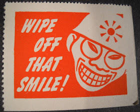 A poster featuring a racist caricature of a smiling Japanese man with the text "Wipe off that smile!"