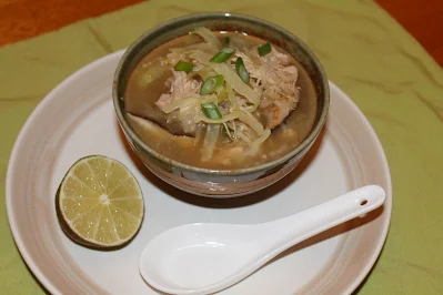 Serving chicken cannage and rice soup with a lime.