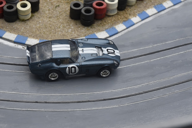 Arial view of a Slot Car Cobra Daytona on a racetrack with curbs and tire stacks