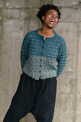 Smiling model wearing hand knitted cardigan