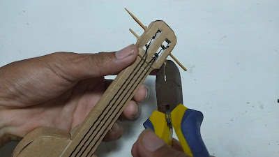 memasang senar miniatur gitar