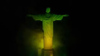Christ the Redeemer statue lit up with the colours of the flag of Brazil