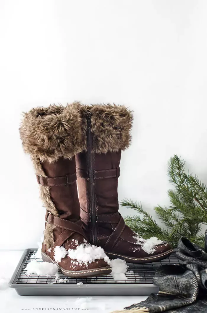 Snow boots and scarf sitting in snow on a DIY boot tray