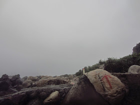 The first red arrow that marks the path amongst the rocks to the Long Dong Snorkeling Cove. 