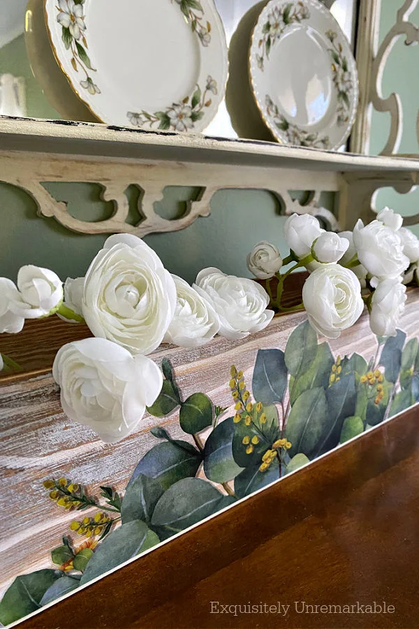 Green and White Decor Accessories including a wooden box with flowers and green plates on a shelf