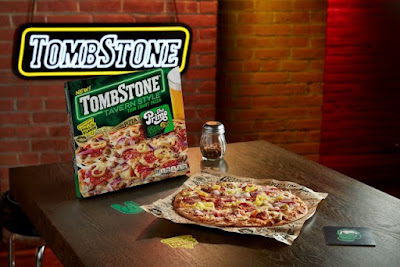 A box of Tombstone Tavern-Style Pizza next to a baked Tavern-Style Pizza.