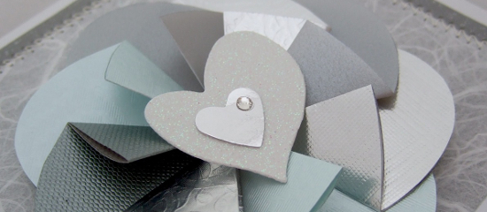 Silver colored paper folded flower for handmade card