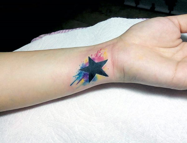 Attractive and lovely wrist tattoos design ideas watercolor with black star designs on the wrist for girls.